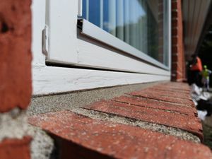 Fugning af vinduer og døre Et vindue som har sandbestrøget fuger så de matcher mørtelfugerne i murværket